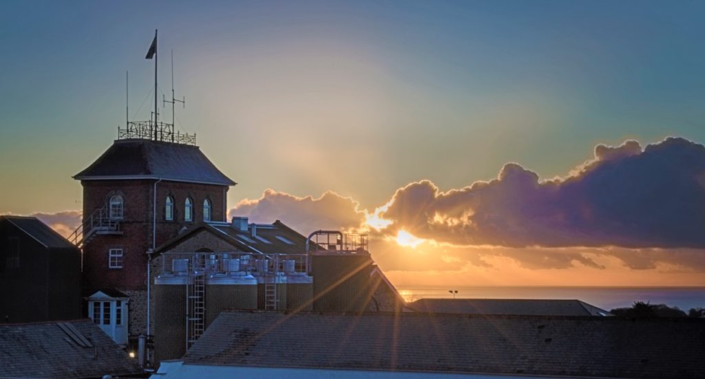 St Austell Brewery with sunset into ocean in background